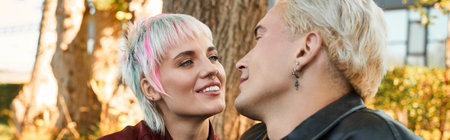 A young couple shares intimate smiles and gazes, surrounded by natures warmth and beauty.の写真素材