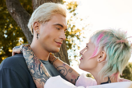Loving couple enjoys a warm afternoon in a park, gazing into each others eyes with smiles.の写真素材