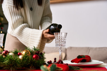 A person pours a sparkling drink into a crystal glass, surrounded by festive decor.の写真素材