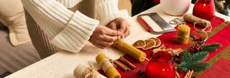Hands assemble festive candles amid warm Christmas decor, celebrating the season.の写真素材