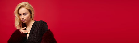 A stylish blonde showcases her winter fashion in a chic red fur coat, bannerの写真素材