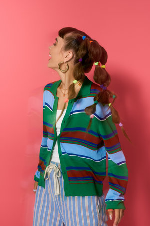 Brightly colored outfit highlights a young woman's joyful expression in a lively setting.の写真素材