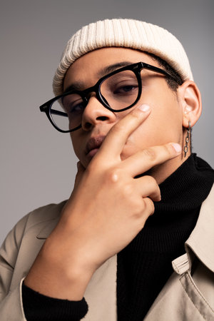 A fashionable young man poses confidently, showcasing his trendy outfit and accessories with flair.の写真素材