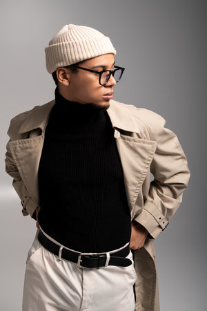 Handsome young man in chic attire poses confidently in a contemporary design space.の写真素材