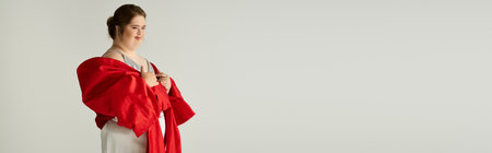 A young woman proudly poses in a stylish outfit, showcasing her unique charm and grace.の写真素材