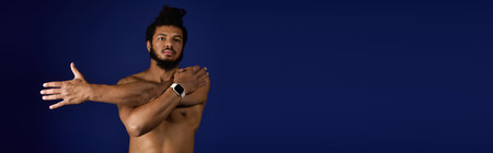 A sportive man with a beard and curly hair stretches his arms against a blue backdrop, banner