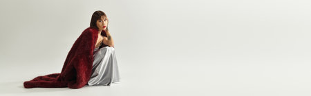 Young woman dressed in fashionable attire poses gracefully, exuding confidence and style.の写真素材