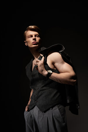 A striking young man embodies modern masculinity under dramatic lighting.の写真素材