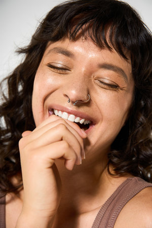 A young woman joyfully smiles in stylish clothes against a vibrant backdrop.