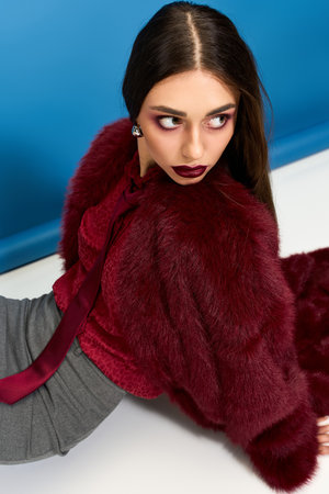 Woman in a stunning outfit sits gracefully on the floor, showcasing an intriguing fashion look.の写真素材