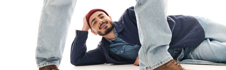 Two brothers in trendy outfits enjoy a playful moment indoors, showcasing their brotherly bond.の写真素材