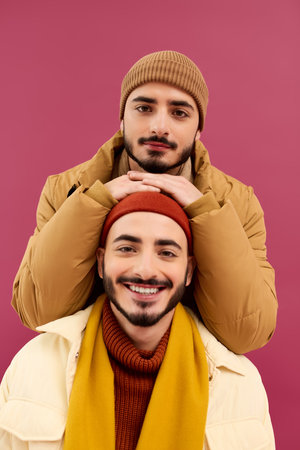 Two handsome twins showcase their unique style with smiles, enjoying a fun moment together.の写真素材