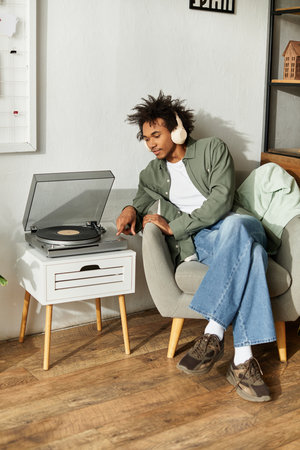 A young handsome African American man listens to music in a comfortable living space.の写真素材