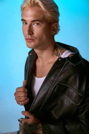 Handsome young man poses confidently in a stylish outfit, highlighting his unique fashion sense.の写真素材