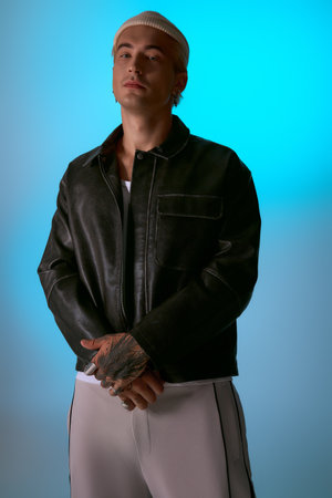 Handsome young man stands poised in a chic outfit, emanating style and confidence.の写真素材