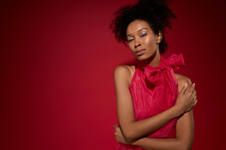 A young woman exudes confidence in her stylish pink dress while embracing her individuality.