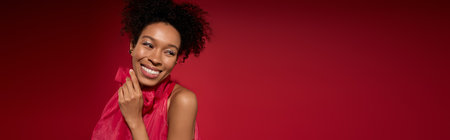 A young beautiful woman beams with happiness, wearing a striking scarf, enjoying a blissful moment.の写真素材