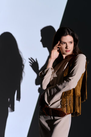 Young woman flaunt stunning fashion, posing elegantly with dramatic shadows next to her twin sister.