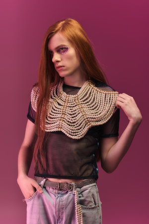 A person showcases their unique style with bold makeup and a striking pearl necklace.