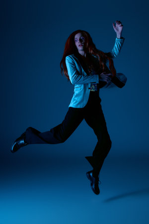 A stylishly dressed person leaps joyfully, celebrating pride and identity in an artful scene.