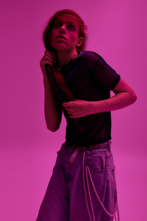 A proud individual styles unique fashion against a bright pink backdrop, celebrating diversity.の写真素材