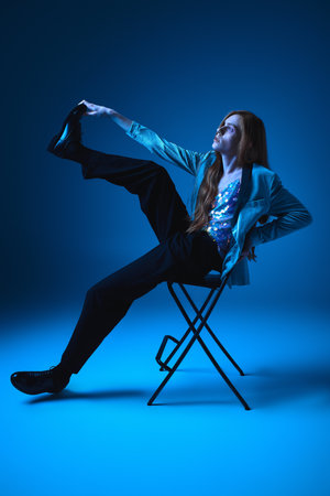 A person showcases their pride and creativity with a striking pose against a vivid blue backdrop.
