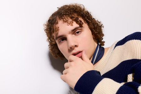 Teen poses playfully in a trendy outfit against a vibrant backdrop.