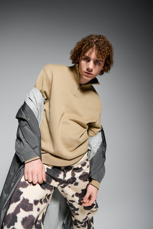 Teenager showcases unique fashion sense while striking an active pose against a sleek background