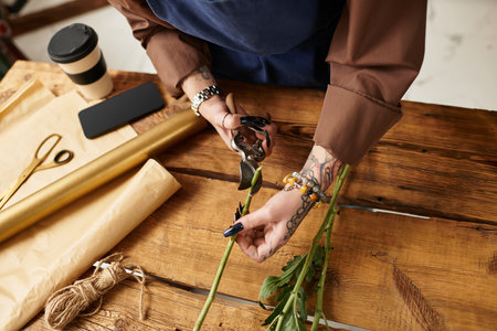 A young woman skilfully arranges flowers in her cozy shop.の写真素材