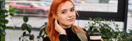 Pretty young woman with red hair relaxes while sipping coffee in a stylish workspace, banner