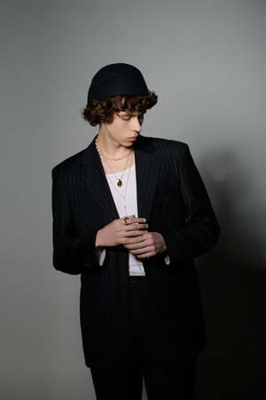 Stylish young man in a fashionable suit poses against a sleek backdrop.の写真素材