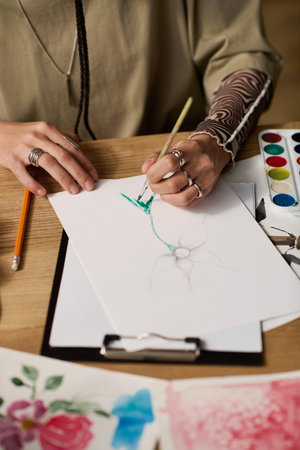 A young woman expresses her creativity through painting at home with stylish decor.