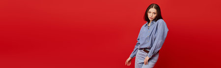 A stylish young woman poses confidently in a light blue blouse and tailored pants.の写真素材