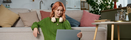 A young woman relaxes in her cozy living room, enjoying her laptop on a nice afternoon.