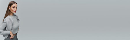 A young woman stands elegantly, showcasing her style and charm in a serene setting.の写真素材