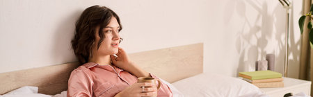 A beautiful woman enjoys a warm beverage while relaxing in her cozy bedroom, embracing comfort.