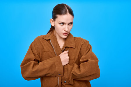 A fashionable young woman expresses her unique style in a cozy outfit, showcasing her beauty.