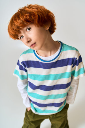 Brightly dressed boy poses confidently, displaying a sense of unique style and personality.