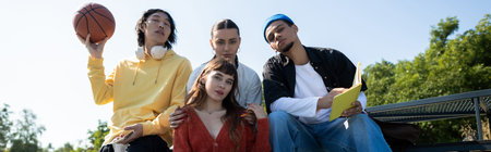 A group of young friends relaxes together under the blue sky, enjoying laughter and connection.