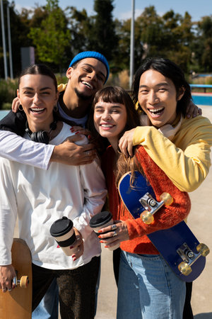 Young friends share laughs and drinks while skateboarding outdoors together.