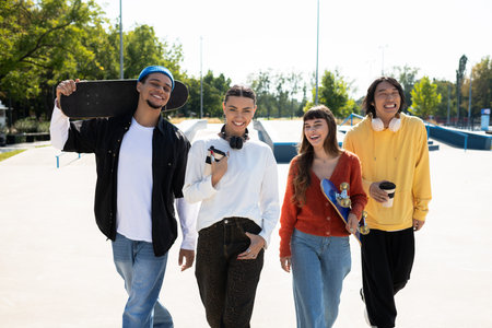 Four friends stroll together at the skatepark, each carrying their favorite gear and smiles.