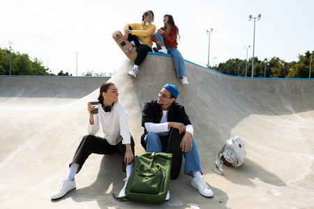 A lively group of young friends shares laughs at the skate park.の写真素材