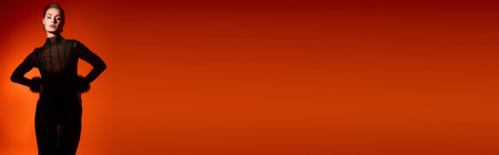 A stylish young woman poses confidently against a bold orange background.
