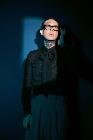 A youthful man dressed in elegant fashion stands confidently, striking a pose with sophistication.の写真素材