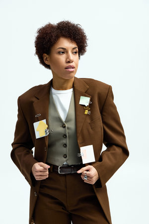 A young beautiful woman dons stylish attire with creative accessories, exuding confidence.