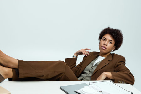 Stylish young woman poses gracefully in a chic office, exuding confidence and elegance.