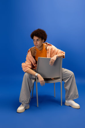 A beautiful young woman showcases her fashion sense while seated in a striking pose.