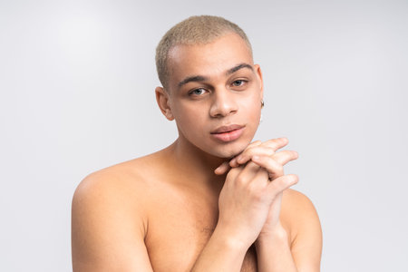 Handsome man exudes charm with a unique style in a minimalist space, captivating all around.の写真素材