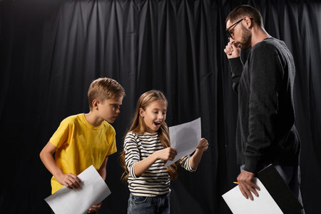 Stylish teacher engages excited children in an interactive theater lesson, exploring their talents.の写真素材