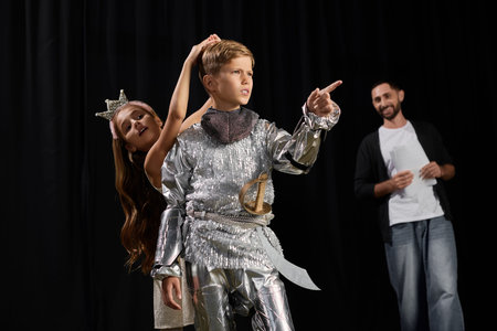 A lively male tutor inspires children in a theater workshop, guiding their creative expressions.